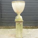 A reconstituted stone urn, on a matched pedestal base,