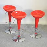 A set of three vintage style red bar stools,