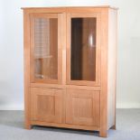 A light oak glazed cabinet,