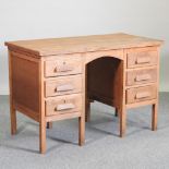 A mid 20th century light oak desk,