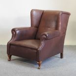 An early 20th century brown leather upholstered armchair