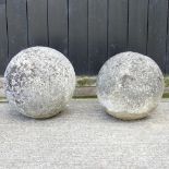 A pair of reconstituted stone spherical lawn markers,