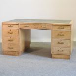 A mid 20th century light oak pedestal desk,