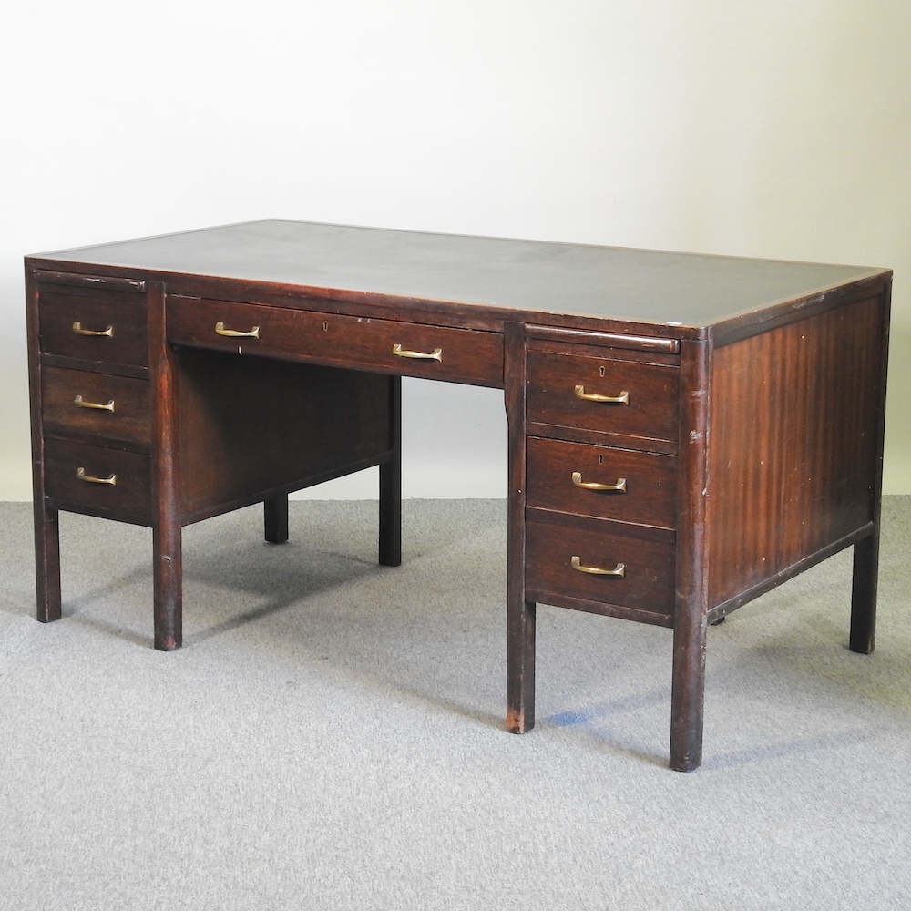 A mid 20th century stained oak desk, with an inset writing surface,