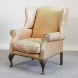 A 20th century cream leather upholstered wing back armchair