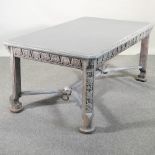 An early 20th century continental and later grey painted dining table, with a carved frieze,