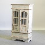 A white painted cabinet, with a slatted front,