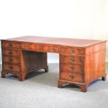 A reproduction walnut pedestal desk, with a red inset writing surface,