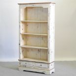 A white painted bookcase, with drawers below,
