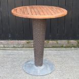 A hardwood high garden table, on a woven support,