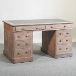 An early 20th century Heals style limed oak twin pedestal desk,