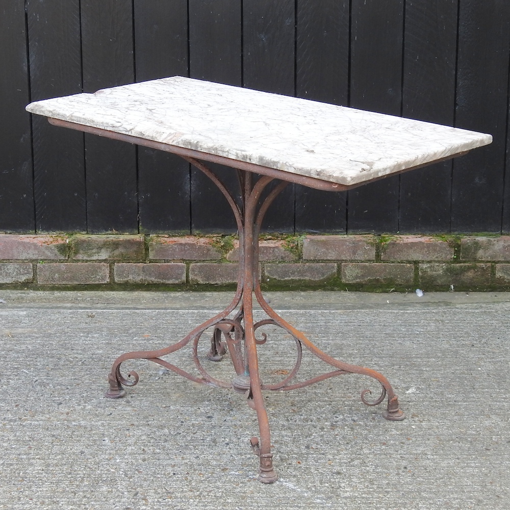 An iron garden table, with a marble top,