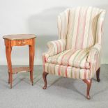 A striped upholstered wing armchair, on cabriole legs,