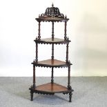 A Victorian burr walnut four tier corner whatnot, of graduated shape, with fret carved decoration,