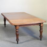 A Victorian mahogany pull-out dining table, with two additional leaves, on turned and fluted legs,