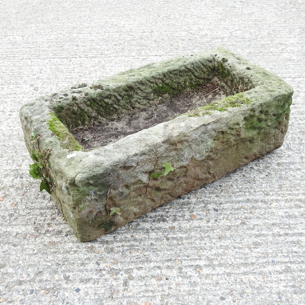 An antique carved stone water trough,