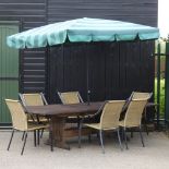 A hardwood extending garden table, with two additional leaves, 310 x 110cm overall,