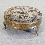 An early 20th century brass and upholstered circular footstool,