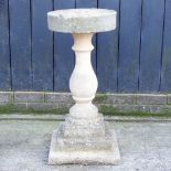 A sharpening stone, on a pedestal base,