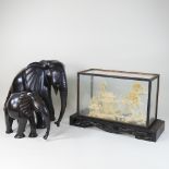 A carved hardwood model of an elephant, together with another smaller and a cork model of a pagoda,