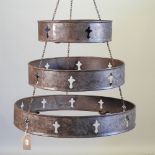 A metal three tier graduated hanging candle holder,
