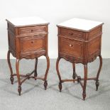 A pair of early 20th century French carved walnut marble top pot cupboards, on shaped legs,