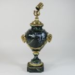 A 20th century green painted metal table lamp, with ram's head decoration,