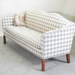 A modern grey and white check upholstered sofa, with a shaped back,