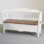 A white painted settle, with a rising seat,