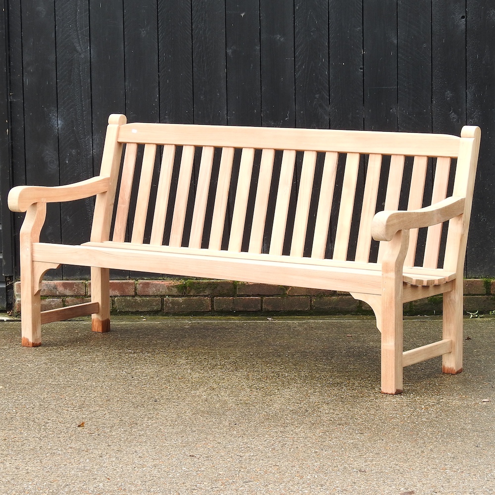 A teak slatted garden bench, with a loose cushion,