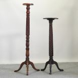 An early 20th century turned mahogany torchere, together with another larger,
