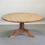 A 20th century circular pine dining table,