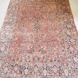 A mid 20th century Persian sarouk carpet, with all over foliate design, on a red ground,
