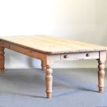 An unusually large antique pine dining table, with a single drawer, on turned legs,