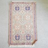 A Turkish woollen rug, geometric design, on a green ground,