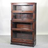 An early 20th century Globe Wernicke oak graduated four tier glazed bookcase, on a plinth base,