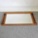 A pine framed wall mirror, with scrolled decoration,
