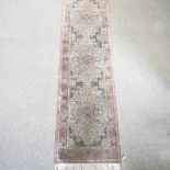 A Persian runner, with three central medallions, on a cream ground,