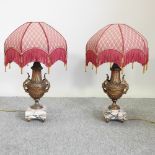 A pair of ornate gilt table lamps, with marble bases and frilled shades,