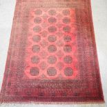 A Bokhara woollen rug, with all over design on a red ground,