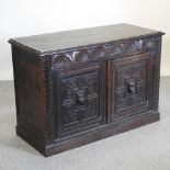 An early 20th century carved dark oak sideboard, with mask decoration,