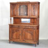 An early 20th century carved oak dresser, with a glazed upper section,