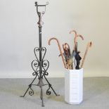 A collection of walking sticks, in a white stick stand,