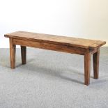 A rustic pine bench, on square tapered legs,