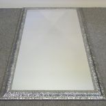 A large silver painted framed wall mirror,