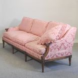A 20th century pink upholstered sofa, of 18th century style, on turned legs,