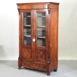 A Victorian walnut glazed two door bookcase, with a drawer below,