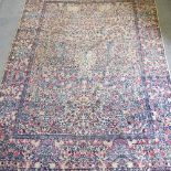 An early 20th century Persian Sarouk carpet, with all over flower and tree design,