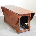 A fruitwood wakes table, with a hinged oval top, on turned supports,