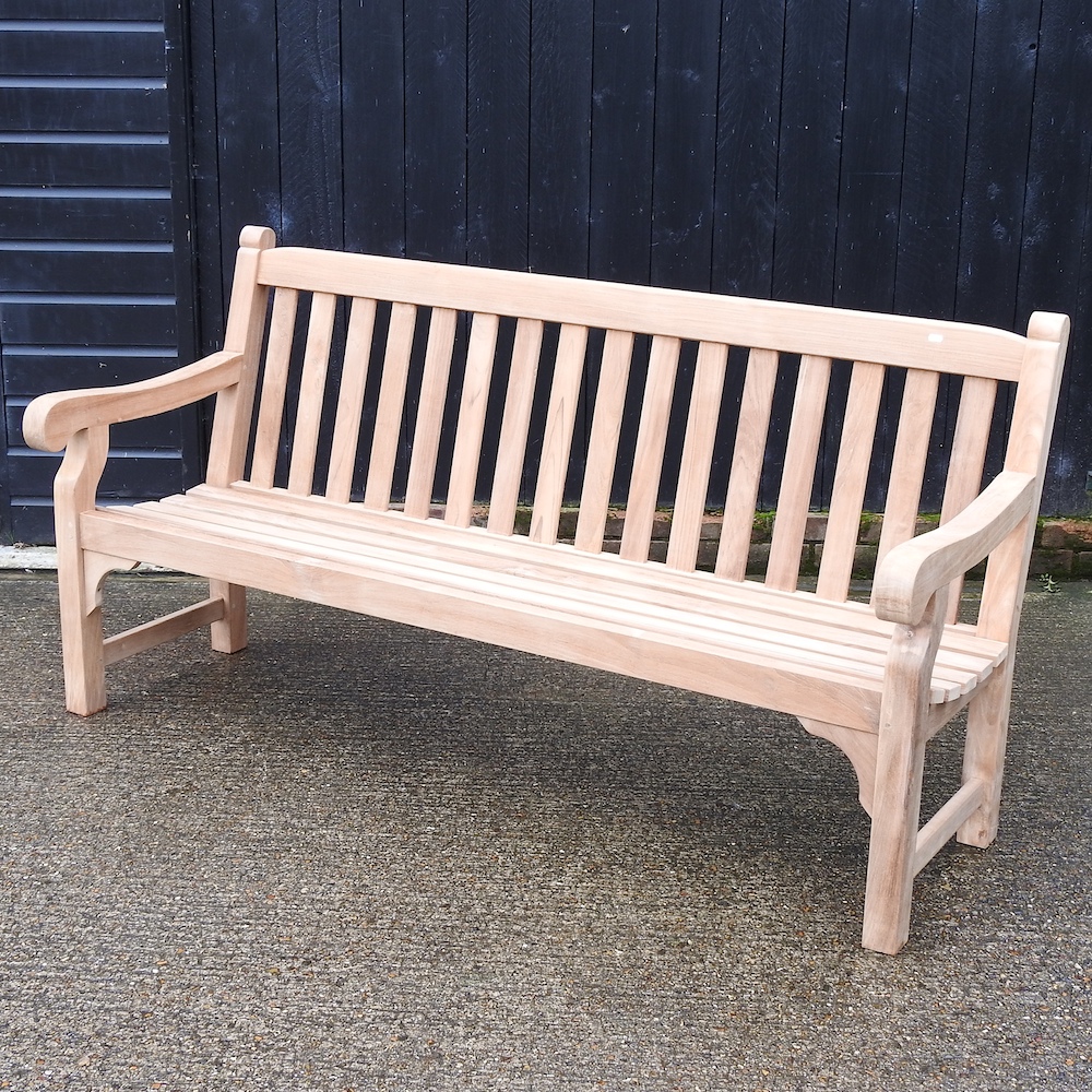 A teak slatted garden bench, with a loose cushion,